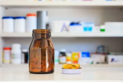Amber medication bottle and pills on a pharmacy counter